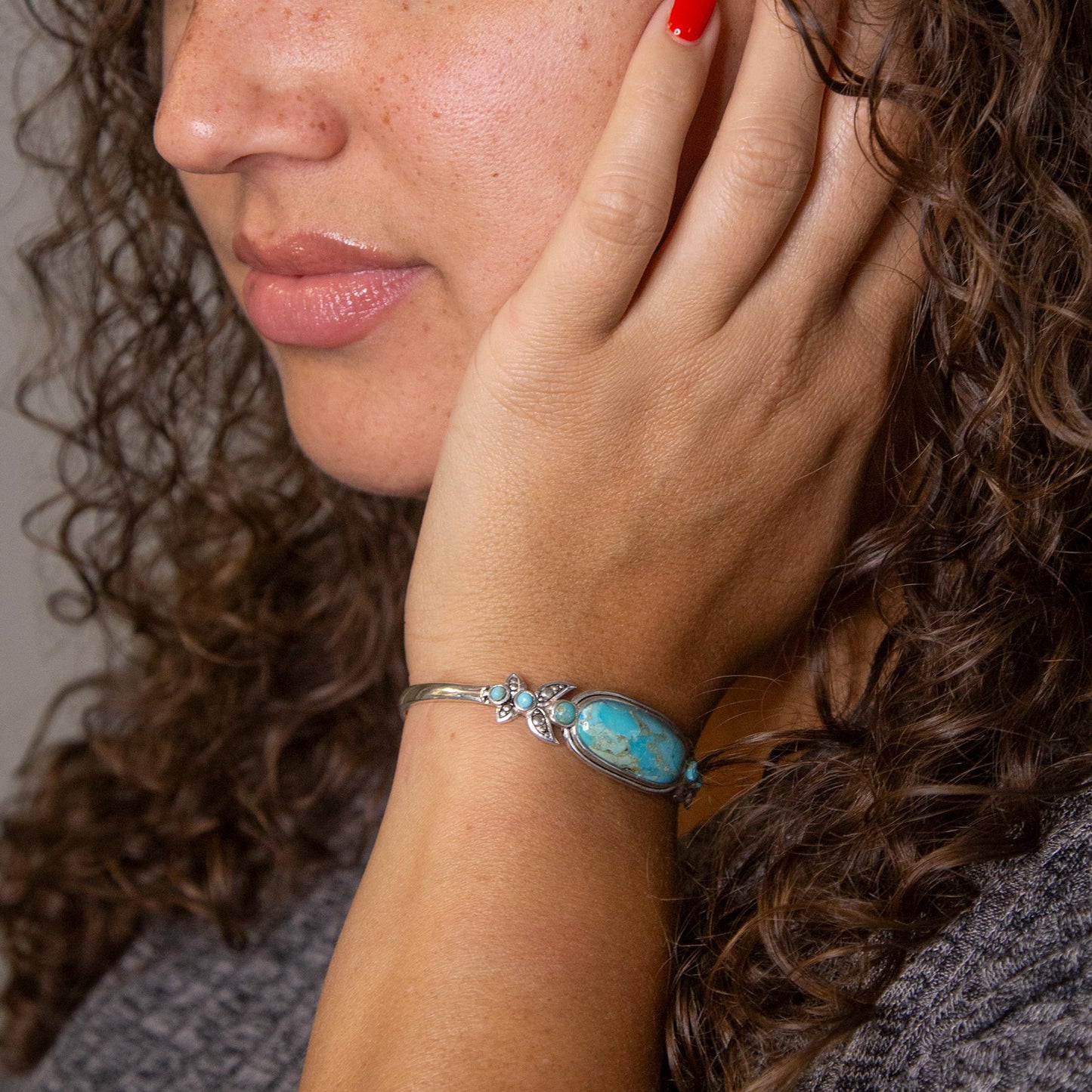 Close-up of a woman wearing a turquoise bracelet on her wrist.