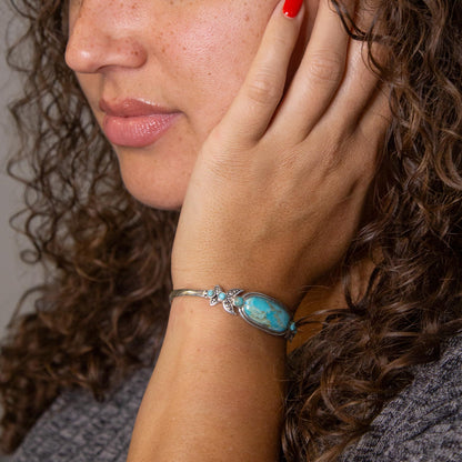 Close-up of a woman wearing a turquoise bracelet on her wrist.