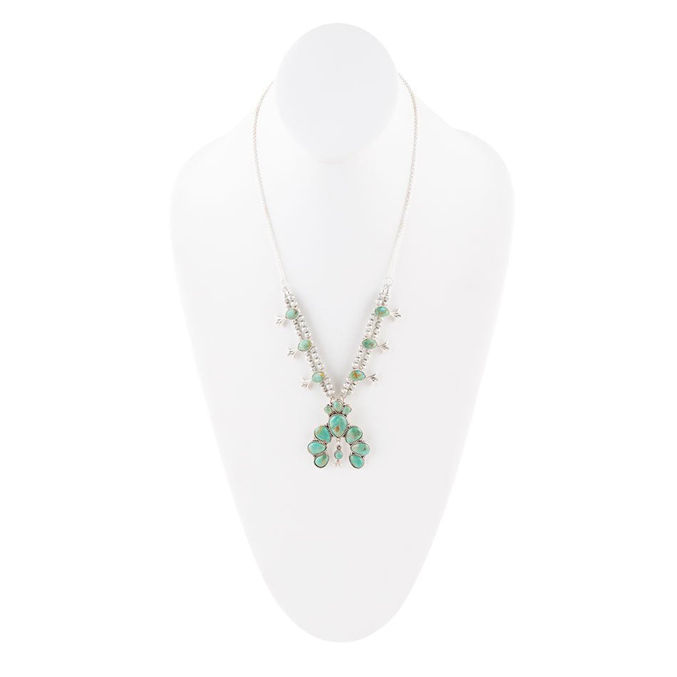Necklace with green pendant on a white stand