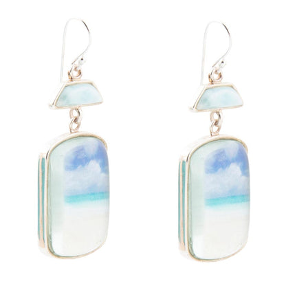 Pair of earrings with cloud and sky design on a white background