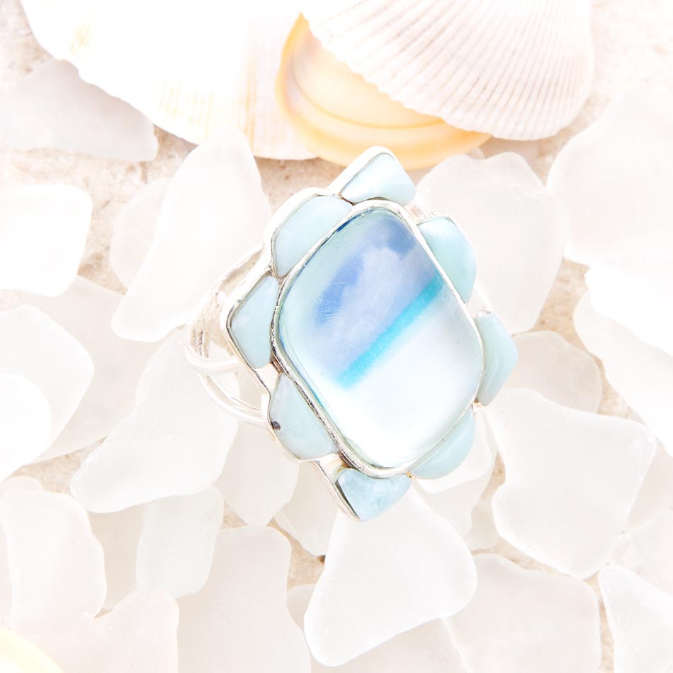 Ring with a blue gemstone on a shell background