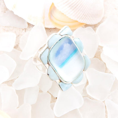 Ring with a blue gemstone on a shell background