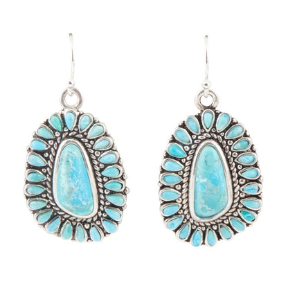 Turquoise earrings with silver detailing on a white background
