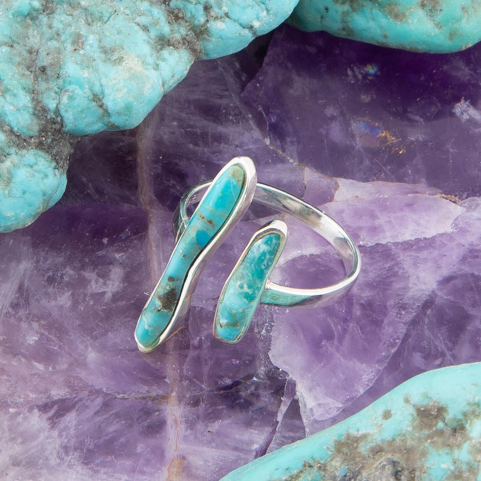 Silver ring with turquoise stones on a purple stone background