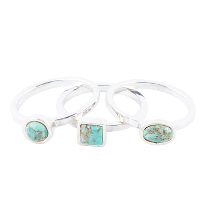 Three silver rings with turquoise stone inlays on a white background