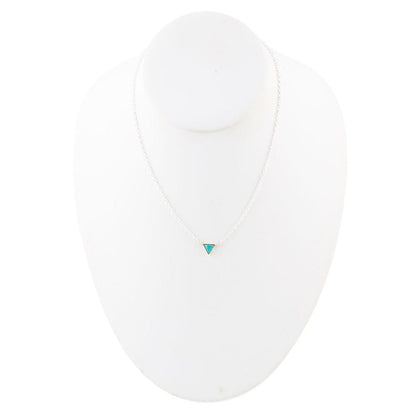 White shirt with a small turquoise heart emblem on a white background