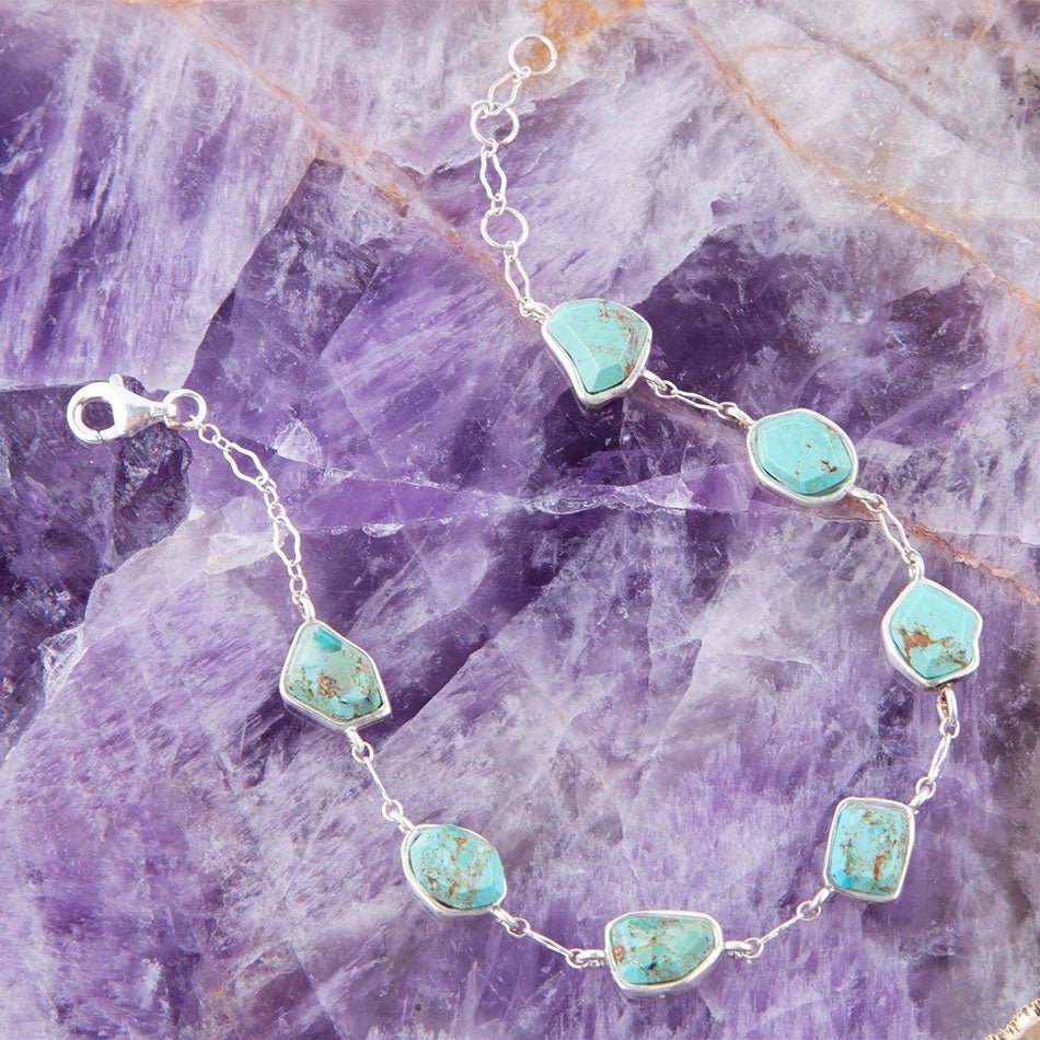 Turquoise stone necklace on a purple crystal background